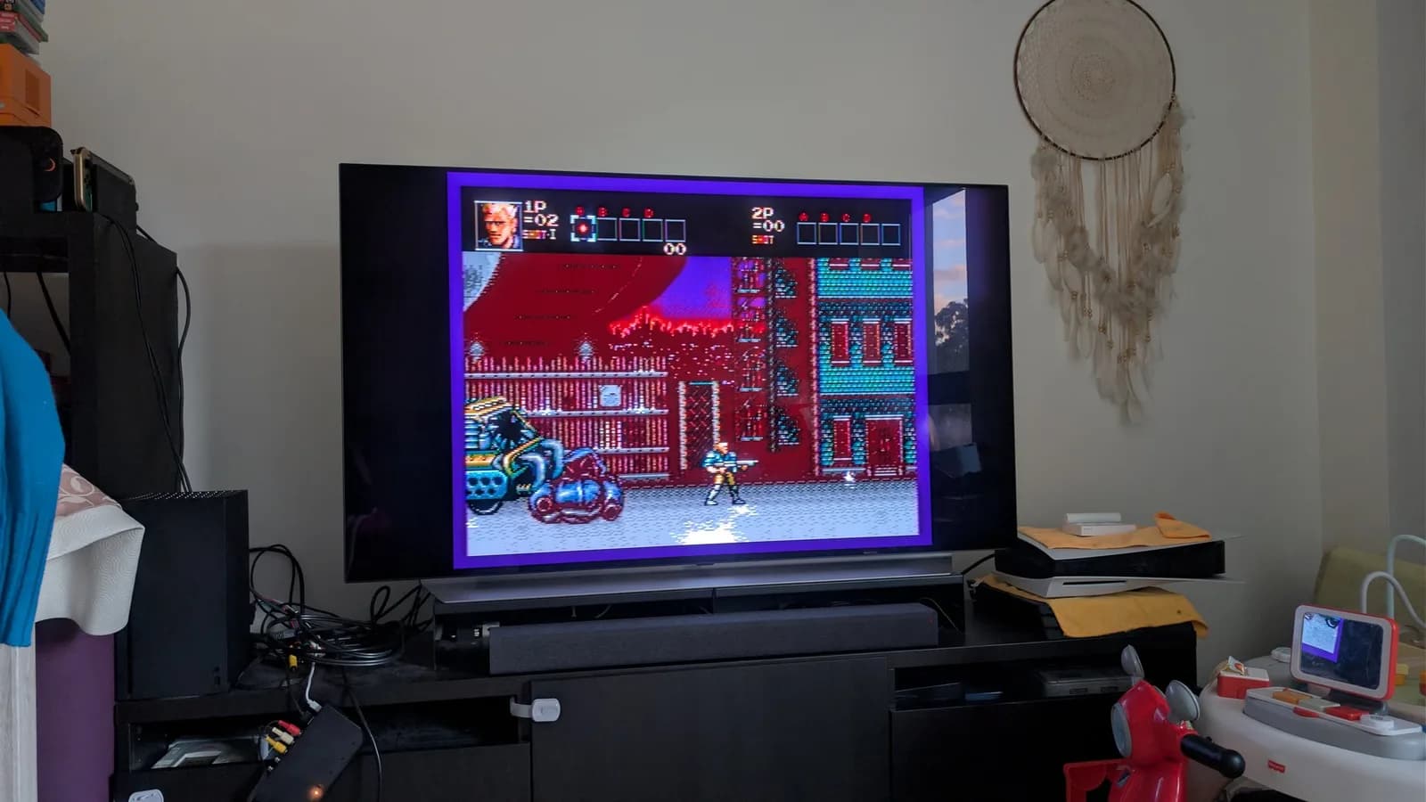 LG C1 OLED TV displaying Contra Hard Corps (Mega Drive), tested on the restored Sega Wondermega HWM-5010, on a media unit with other consoles and AV cabling below.