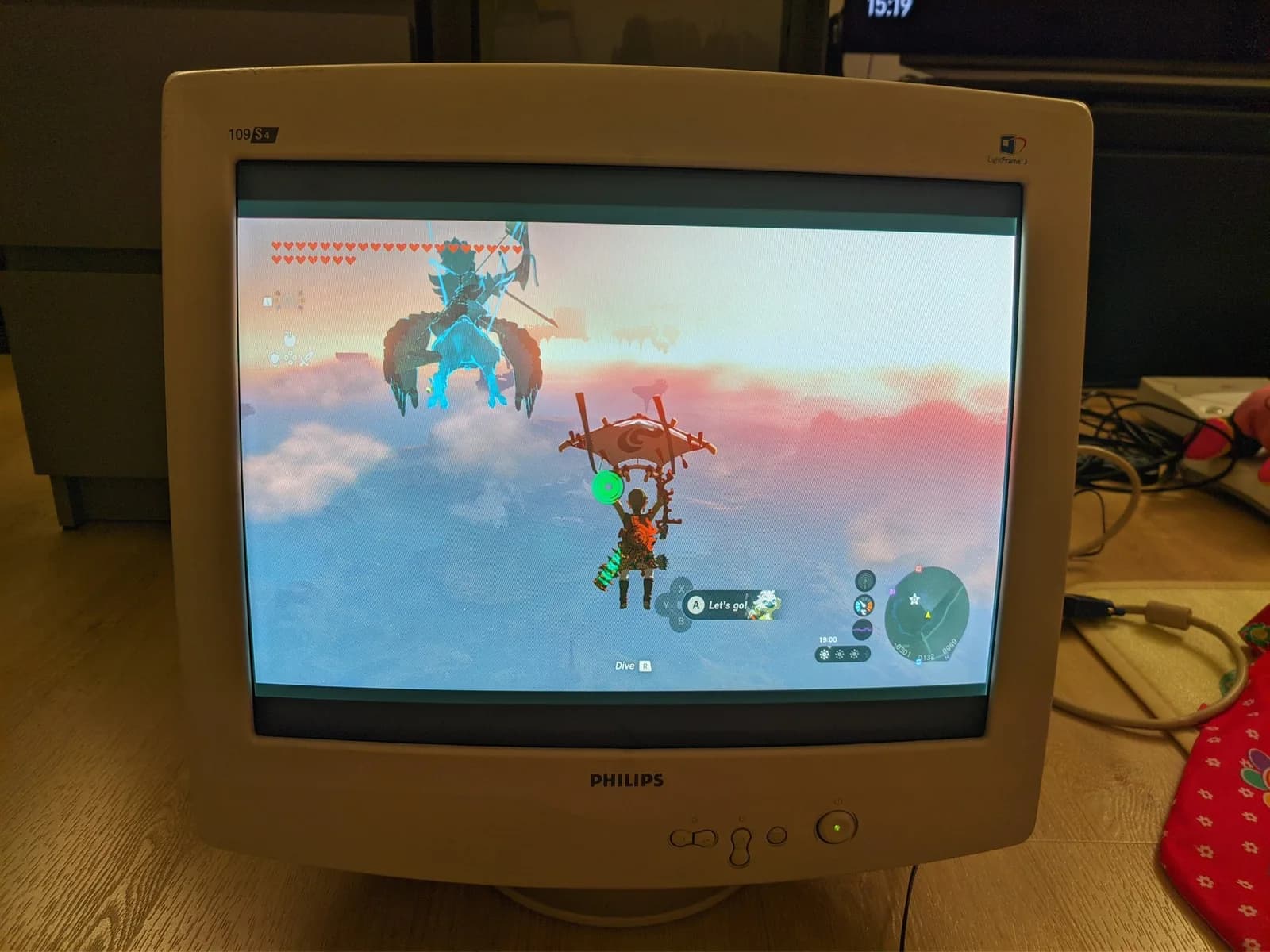 Philips 109S4 shadow-mask CRT (beige, curved) running The Legend of Zelda: Tears of the Kingdom, Link gliding above the clouds accompanied by the flying sage's spirit.