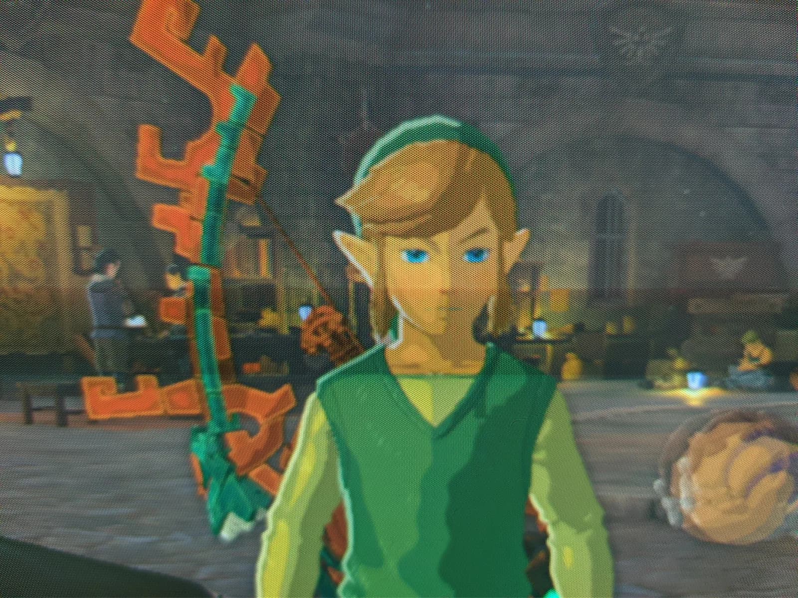 Close-up of Link on the Philips 109S4 shadow-mask CRT in The Legend of Zelda: Tears of the Kingdom, the mask's dot structure faintly visible over his face in a warm-lit interior.