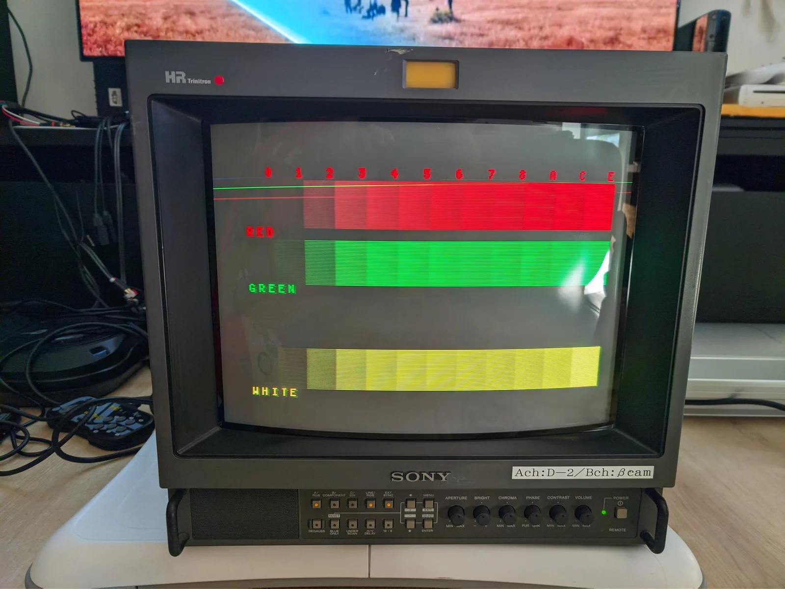 Sony PVM-14M4J displaying color bars test pattern showing red, green, and yellow bars with missing blue channel output during repair diagnostics.