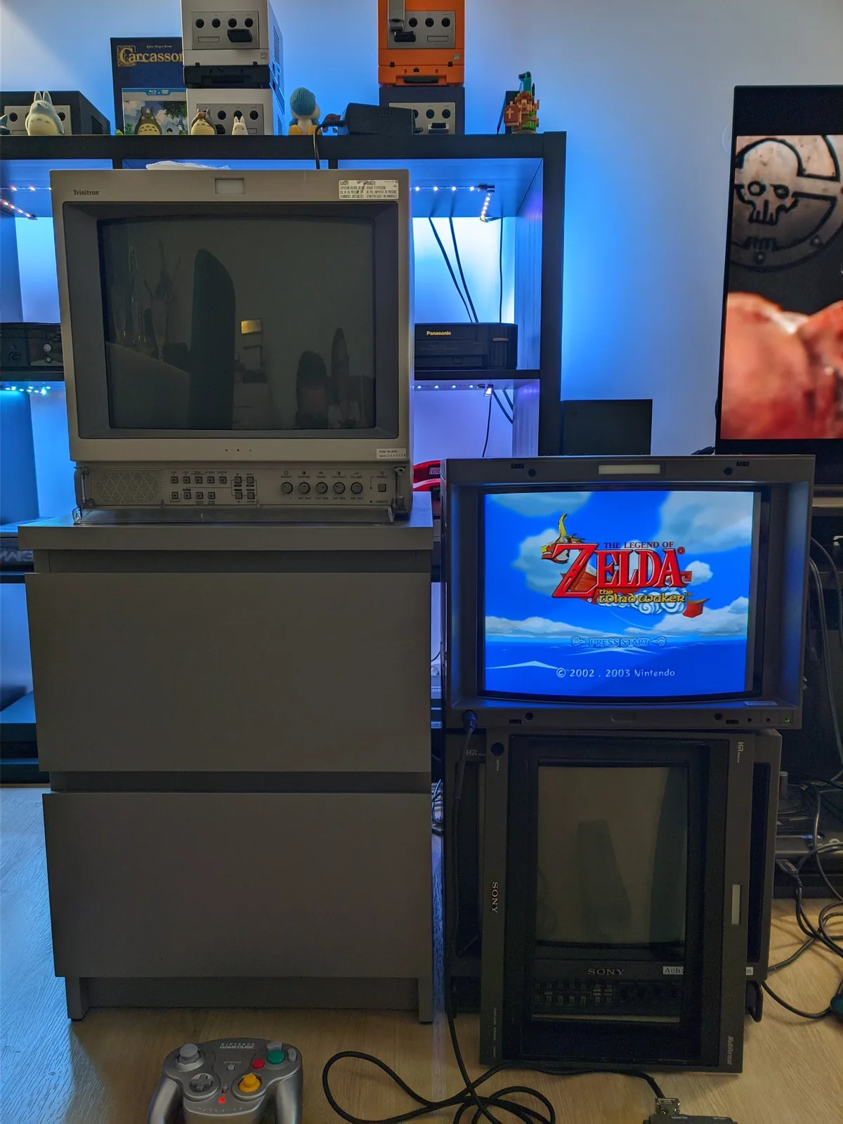 Sony BVM-D14H1E showing The Legend of Zelda: The Wind Waker with its front fascia removed; a Sony PVM-14L2MDJ monitor is also in shot, and a GameCube WaveBird controller sits on the floor in front.
