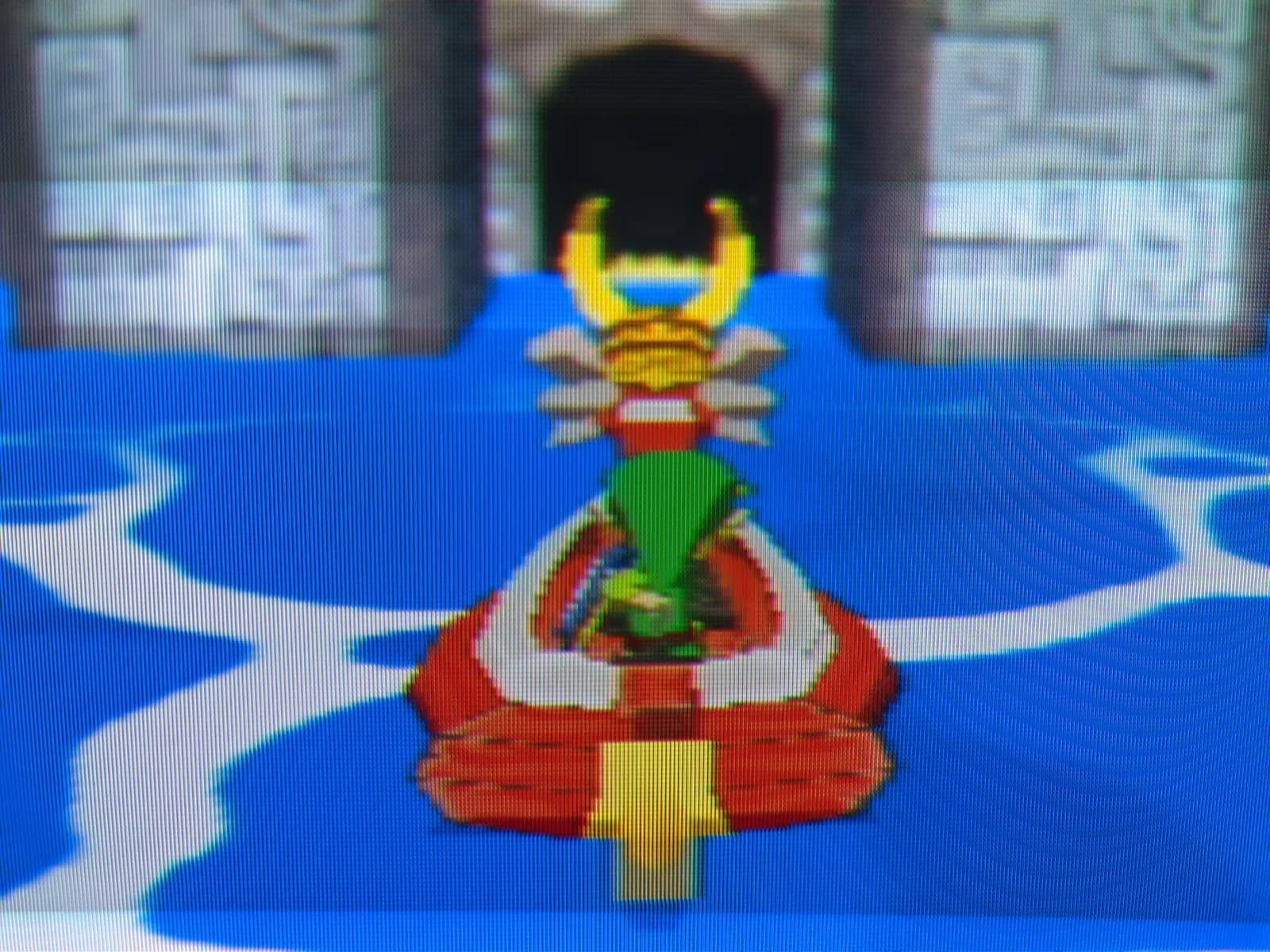 Close-up of the Sony BVM-D14H1E screen showing The Legend of Zelda: The Wind Waker gameplay at 480p, a red boat with a lion figurehead on blue water, aperture-grille scanlines visible.