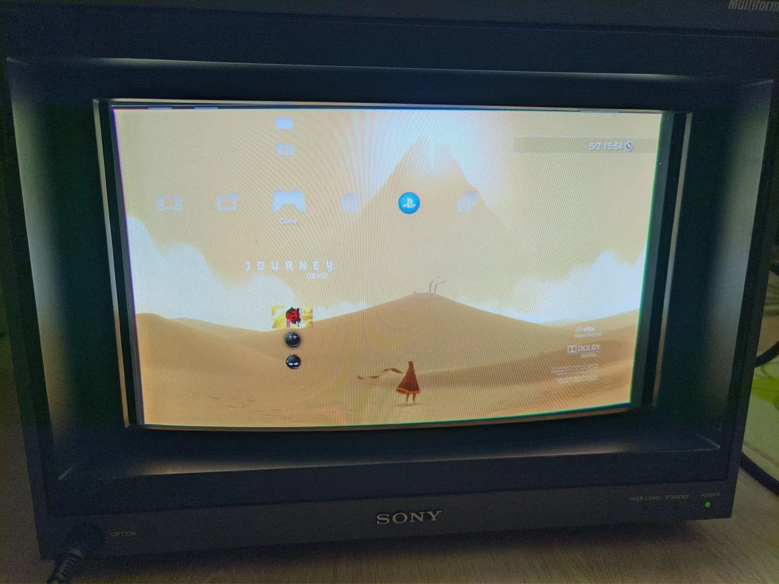 Sony BVM-D14H1E CRT showing the PlayStation 3 XMB menu with the Journey demo highlighted, its desert artwork and robed character on screen.
