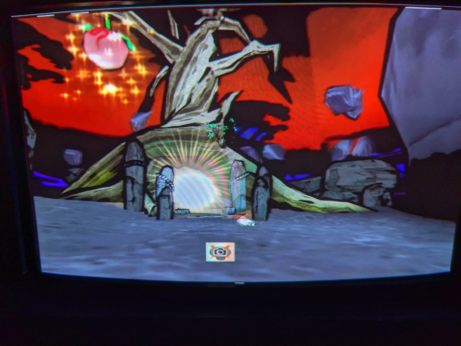 Okami displayed on the Sony BVM-D14H1E CRT monitor: the white wolf Amaterasu before a withered tree and stone pillars under a red sky, in the game's ink-painting art style.