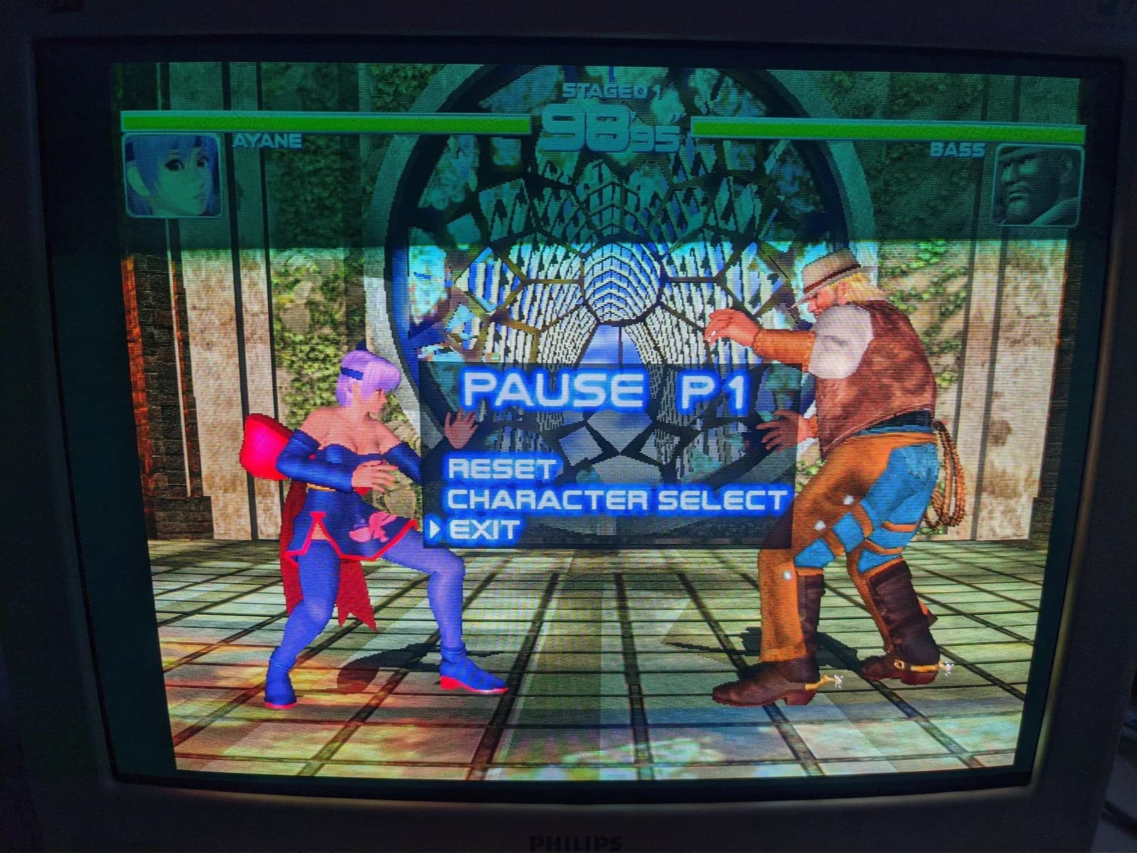 Philips 109S4 shadow-mask CRT running Dead or Alive 2 on Dreamcast, paused mid-fight (Ayane versus Bass) with the PAUSE P1 menu on screen.