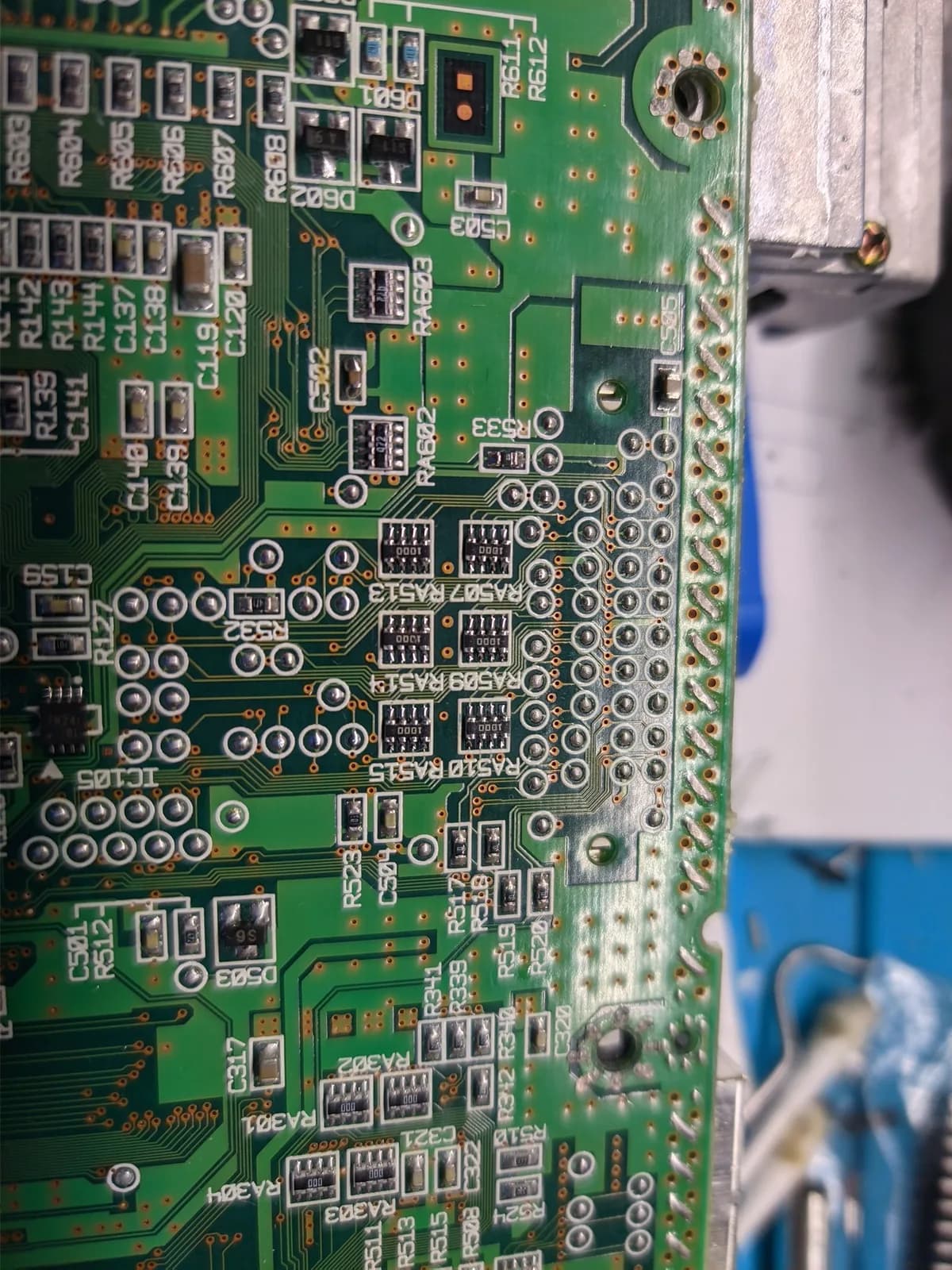 Close-up of the Sega Dreamcast VA0 motherboard showing the resistor arrays (RA-series positions) and an IC, fitted for the VA0 mod that drops the GD-ROM connector voltage from 5V to the 3.3V the GDEMU needs.