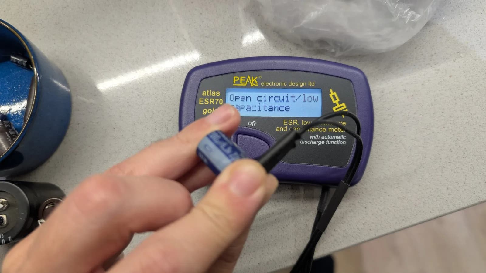 A PEAK Atlas ESR70 meter reading open circuit / low capacitance while testing a PSU capacitor, confirming it dead.