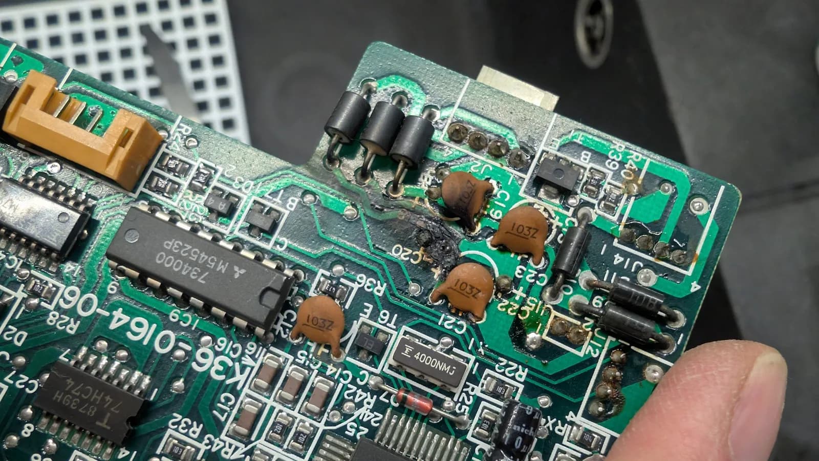 Blown-capacitor damage on the FDD controller PCB, the burnt area and discoloured traces from the failure.