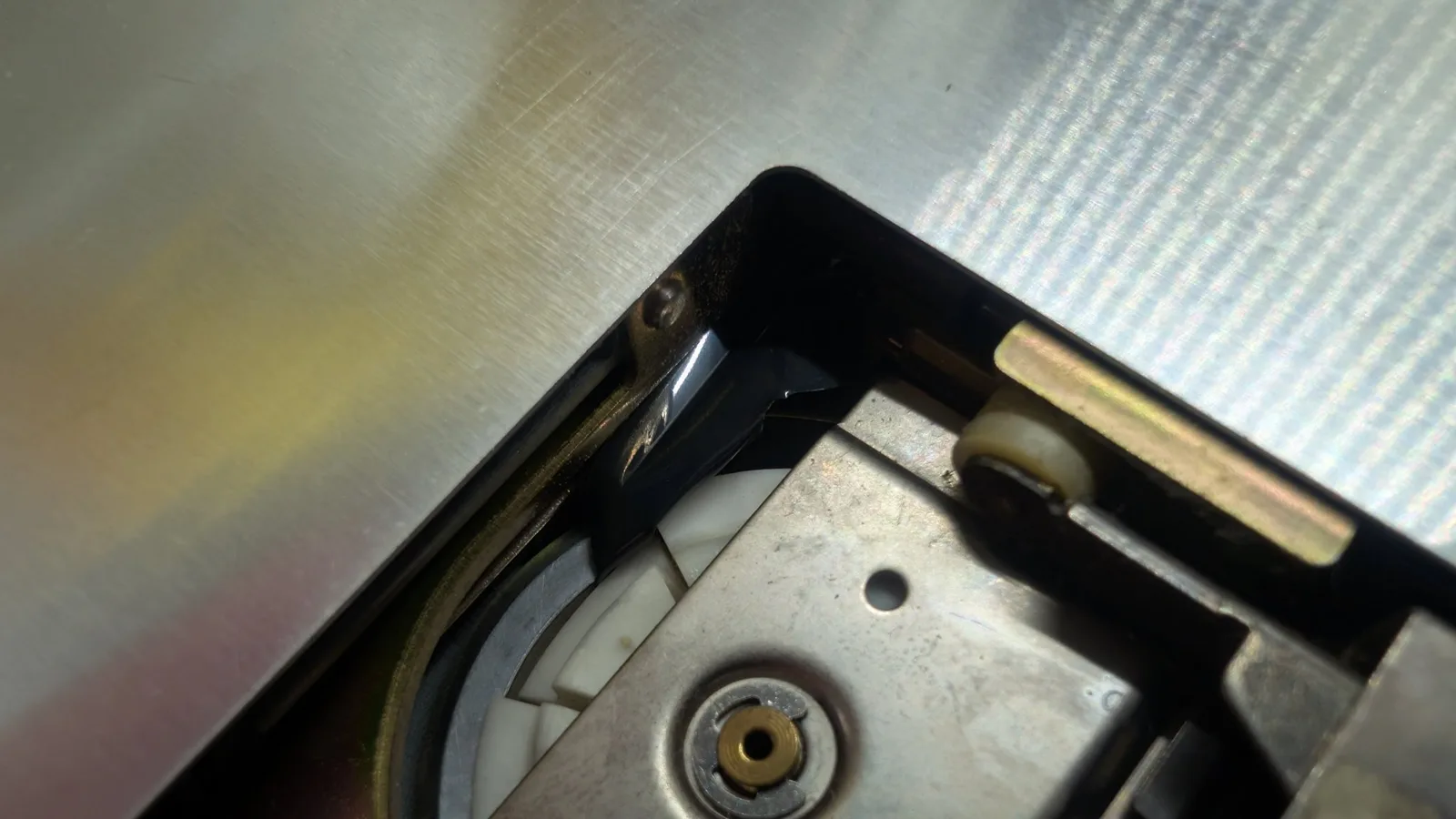 The Sharp X68000 floppy drive spindle mechanism with a torn fragment of floppy-disk magnetic media lodged inside the drive.