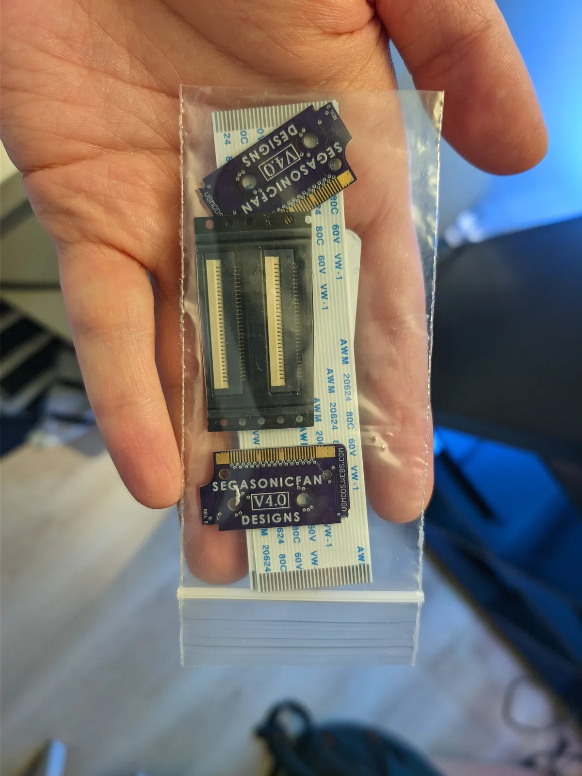 Virtual Ribbon 4.0 by SegaSonicFan held in hand, showing ribbon cable connector with mounting bracket and flex cable assembly for Virtual Boy repair.