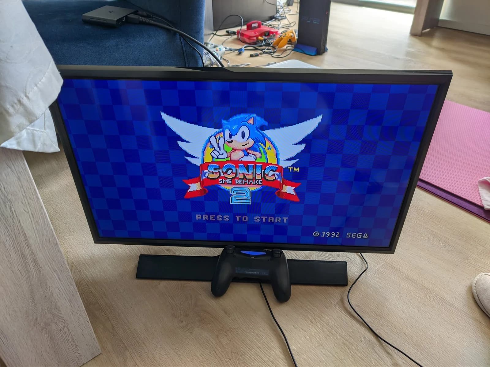 Sony Vita TV displaying Sonic SMS Remake 2 title screen with controller on wooden desk, post-CFW installation.