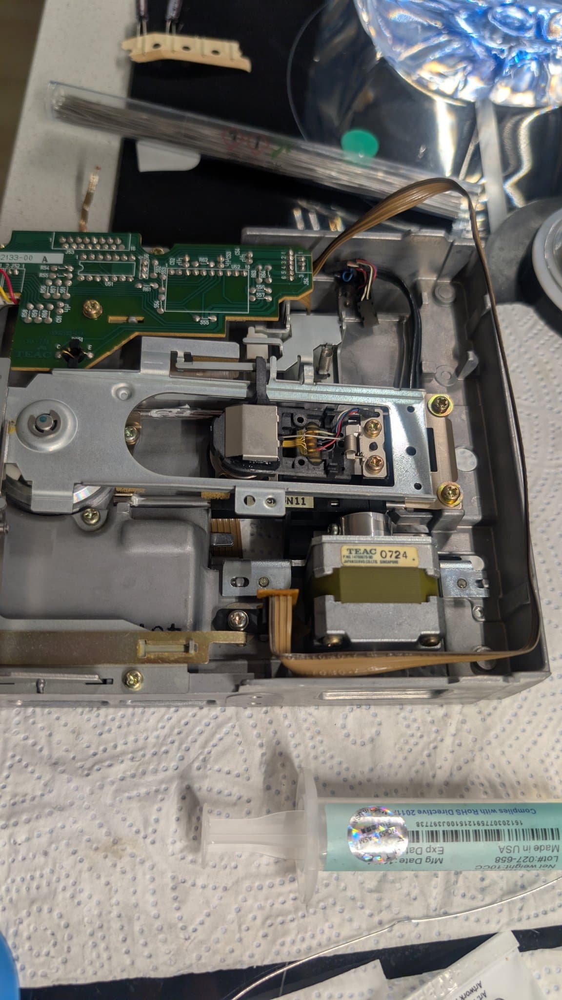 A floppy disk drive from the Sharp X68000 Pro II in its metal housing, being cleaned and relubricated.