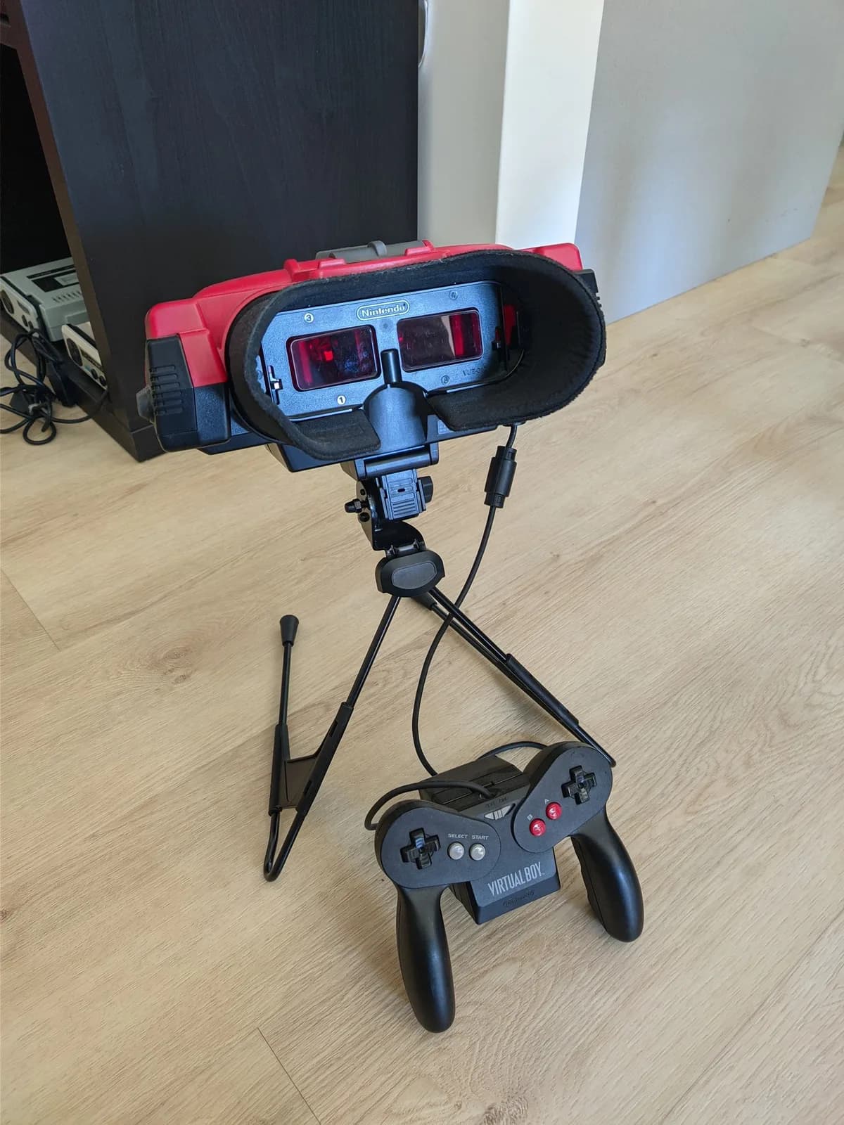 Nintendo Virtual Boy with Virtual Ribbon 4.0 mounted on Repair Box stand, controller connected, showing display alignment jig installation setup.