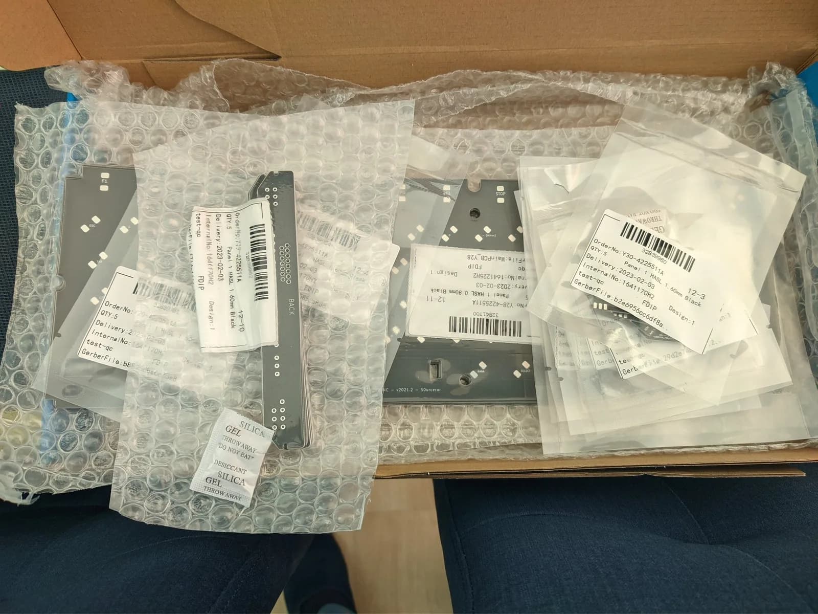 JLCPCB PCB arrivals in bubble wrap: HIC-1 sound board with replacement MLCC capacitors, Carnivore 2 flashcart, and Sony MSX keyboard PCB with shipping labels visible.