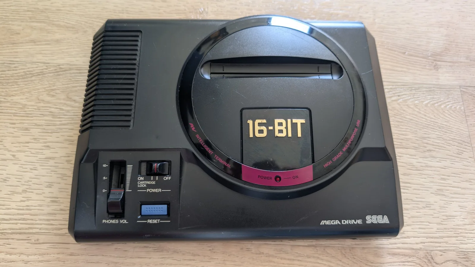 Sega Mega Drive 16-Bit console displaying cleaned black shell, power connector, and AV ports after recapping and solder touch-up work.