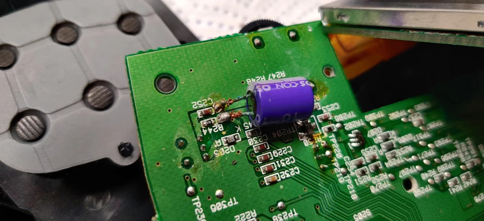 Close-up of Sega Nomad PCB showing removed capacitor and damaged solder joints from poor aftermarket screen installation work.
