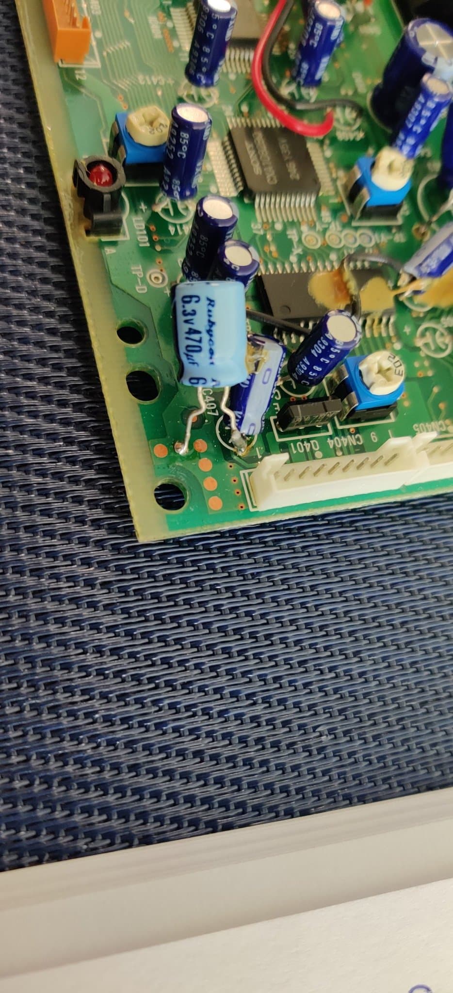 Sega Mega-CD 2 motherboard showing the factory bodge wiring with blue capacitors and IC chips.