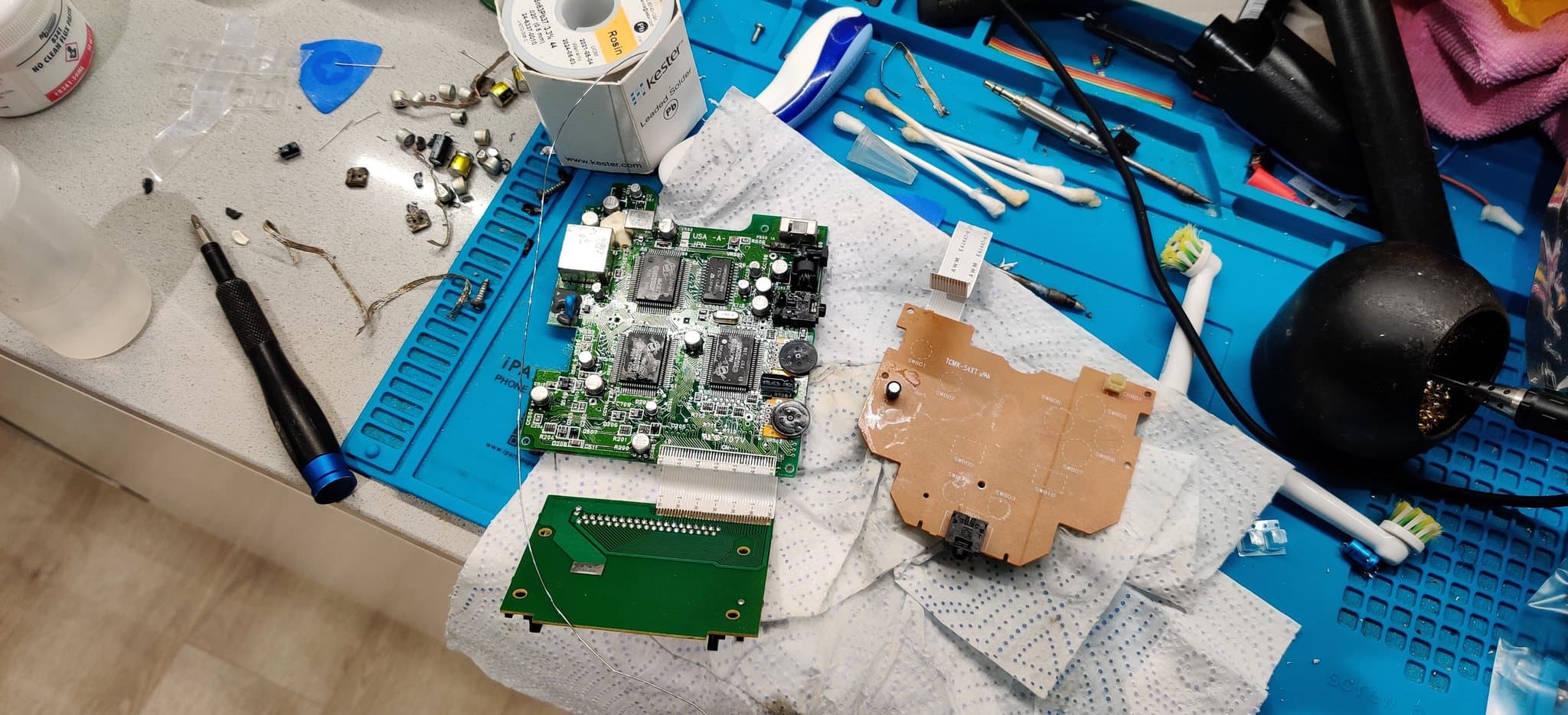 PC Engine GT boards repopulated with new capacitors plus the ceramic caps for the jailbar fix: the mainboard, the controller board and the daughterboard, on the work mat.