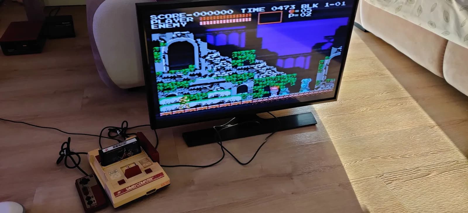 Famicom connected to display running Castlevania III; console shows composite output with vibrant colors, fresh capacitors installed, yellow plastic housing visible.