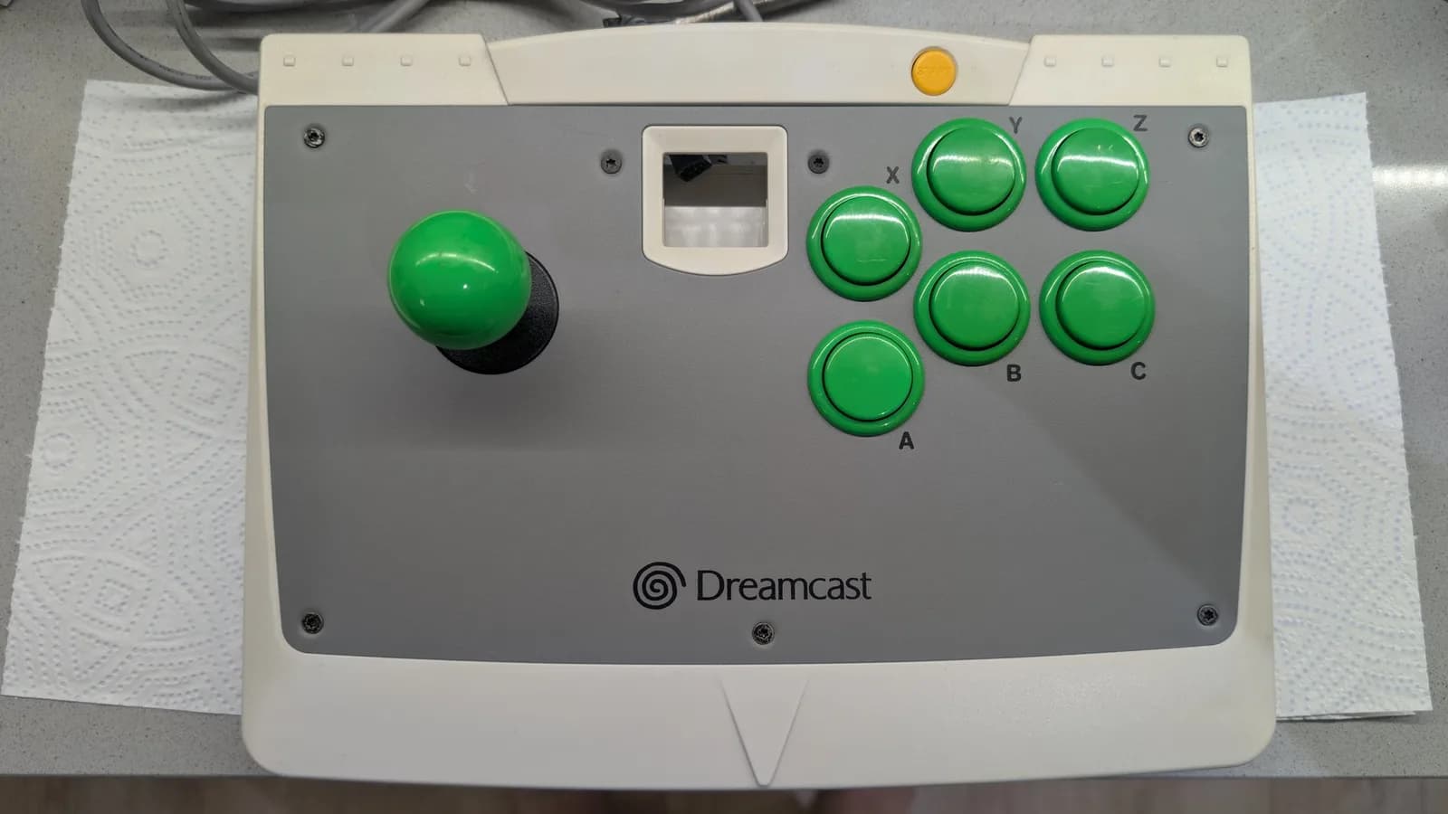 Dreamcast arcade stick with green buttons labeled X, Y, Z, A, B, C after cleaning and lubrication during VA0 refurbishment.