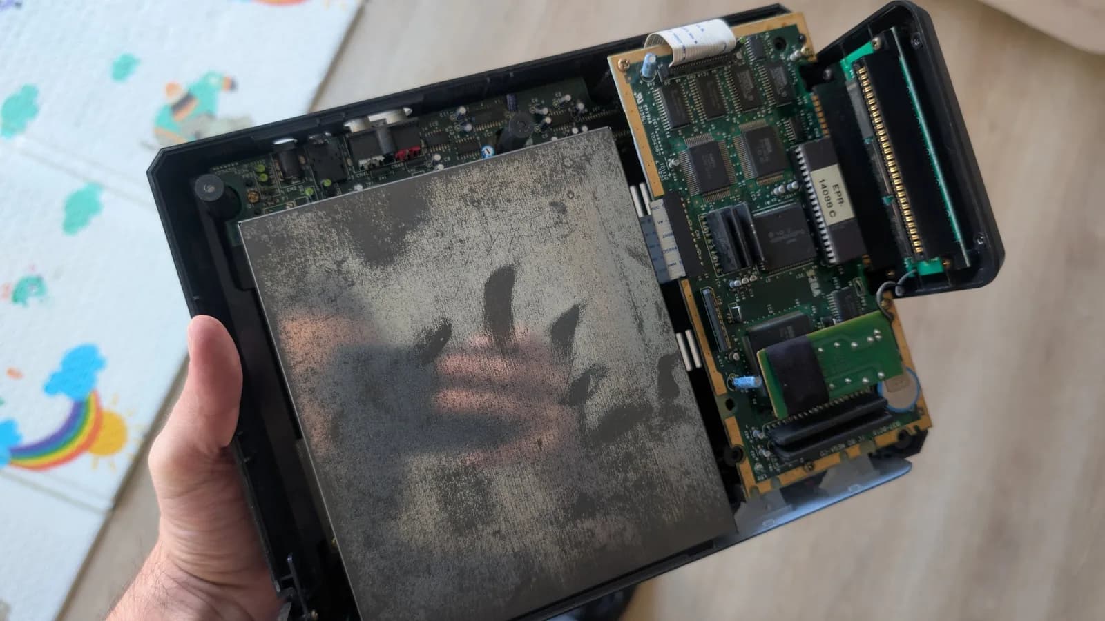 Sega Mega-CD 1 opened showing heavily corroded circuit boards with leaked capacitors; internal PCBs visible on right side.