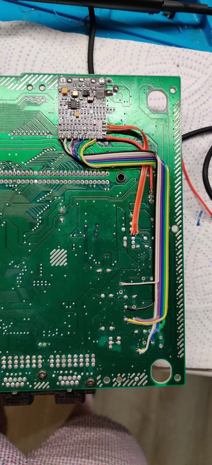 Mega Drive II motherboard with 3BP triple bypass mod installed, showing multicolored wires soldered to main board and daughter board assembly.