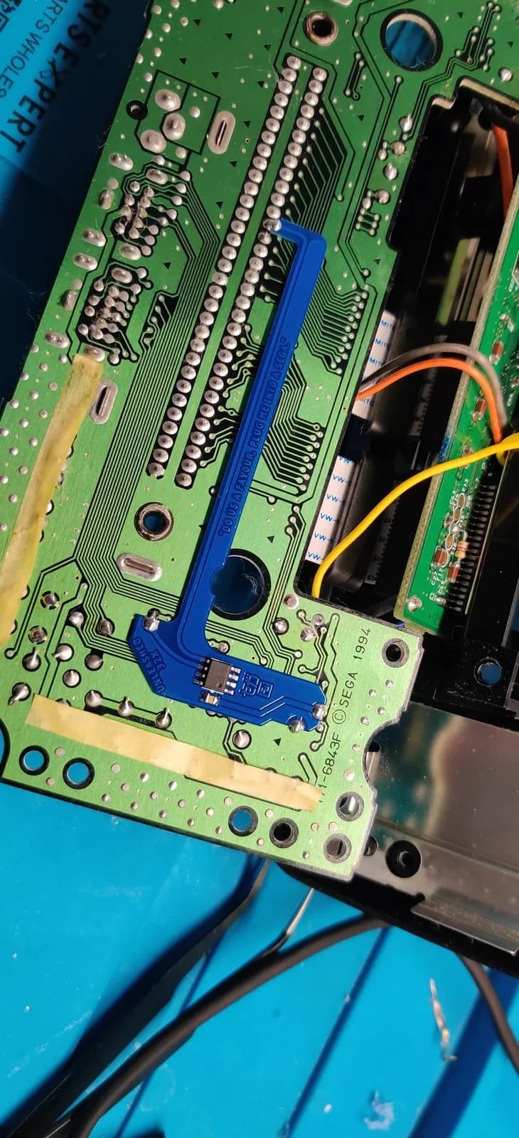 Blue quick-solder board (QSB) soldered directly onto a Sega 32X PCB for the switchless auto-hertz PAL/Japanese region mod.