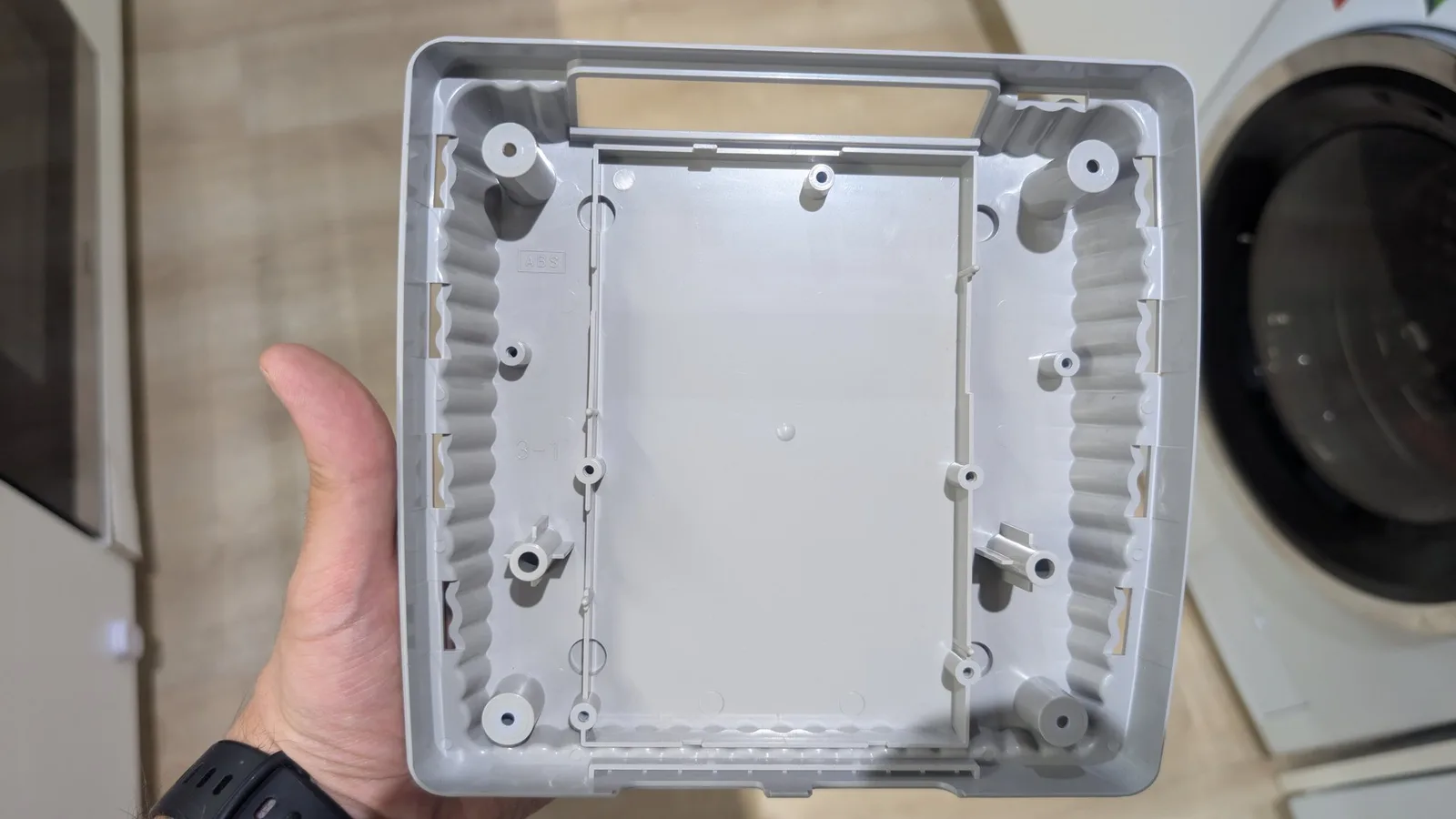 Interior of Super Famicom Jr. shell showing capacitor replacement work, cleaned white plastic housing with mounting posts and internal structure visible.