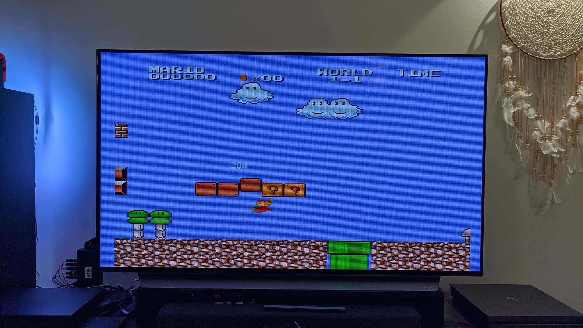 Twin Famicom displaying Super Mario Bros on CRT monitor with NESRGB mod installed, wireless controller in use.