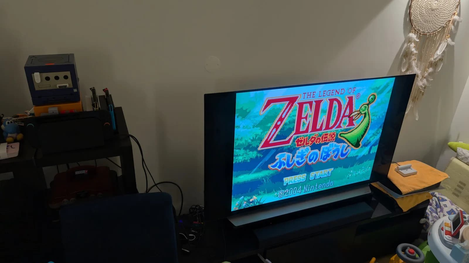 The Legend of Zelda: The Minish Cap title screen (Japanese, Zelda no Densetsu: Fushigi no Boushi, PRESS START, 2004 Nintendo) running on a flat-panel TV through the Game Boy Player.