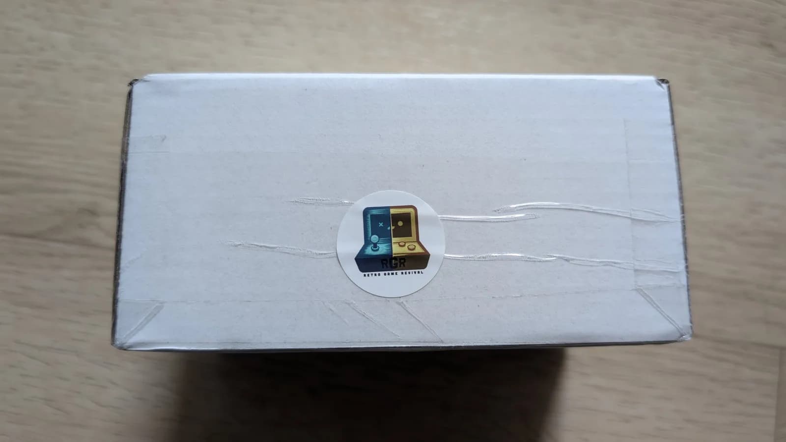 White box with circular Sega Game Gearish logo sticker, containing aftermarket Nomad battery pack from PointerFunction.