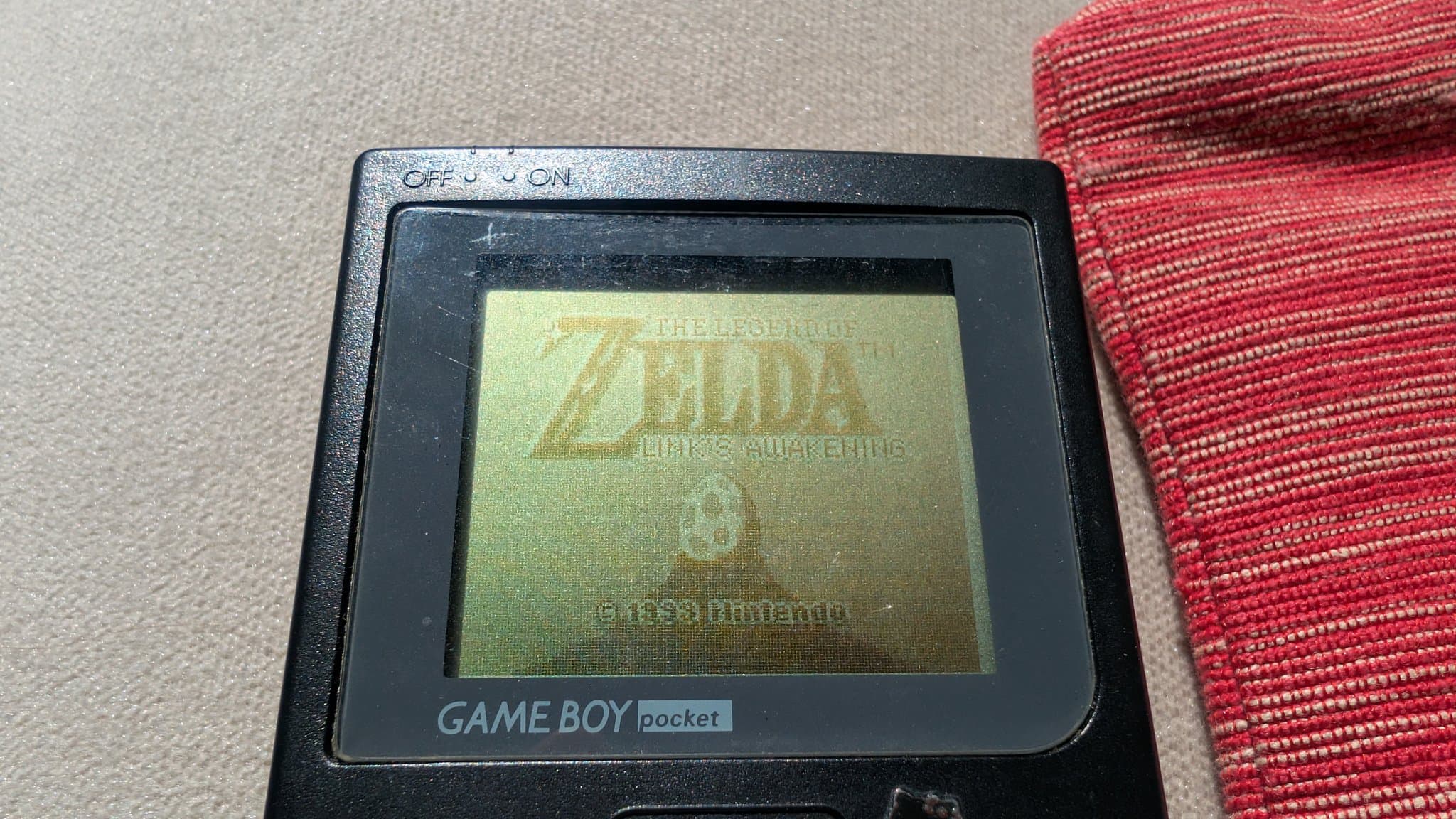 Game Boy Pocket displaying Zelda: Link's Awakening title screen on restored LCD after capacitor replacement and cleaning restoration work.
