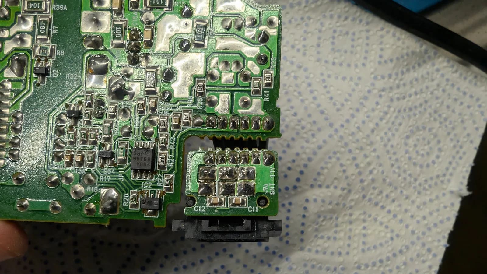 Close-up of the N64 PSU board showing the reflowed solder joints near the power connector after the recap.