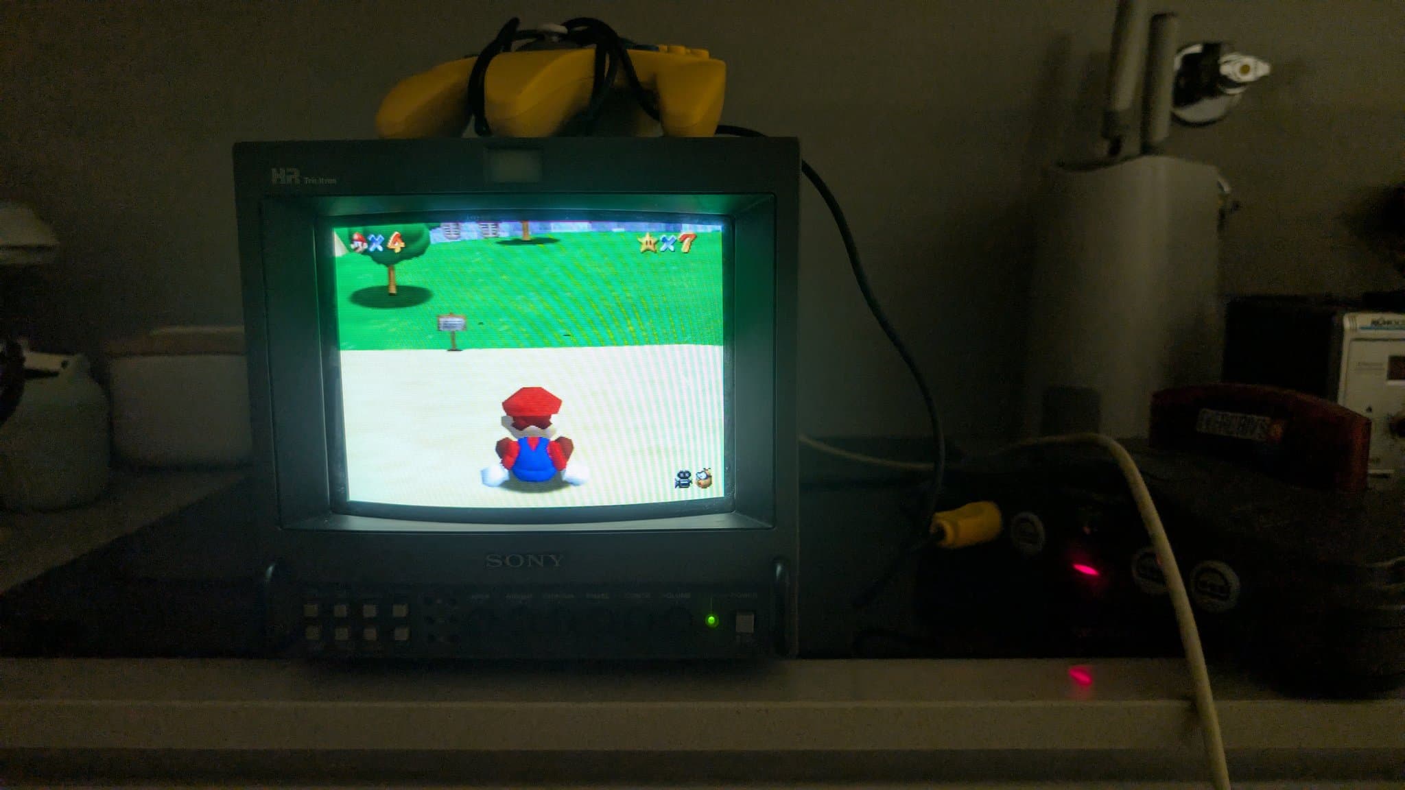 Restored Nintendo 64 running Super Mario 64 on a Sony CRT for validation, with a controller resting on top of the screen.