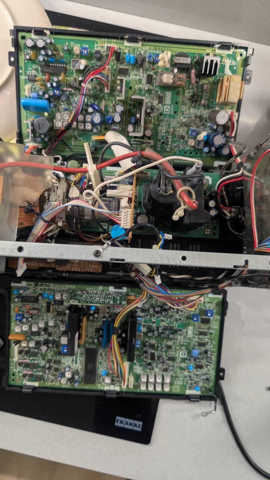 Interior view of Sony PVM-6041Q showing main PCB and deflection board with cleaned components, reassembled wiring, and capacitors after restoration.