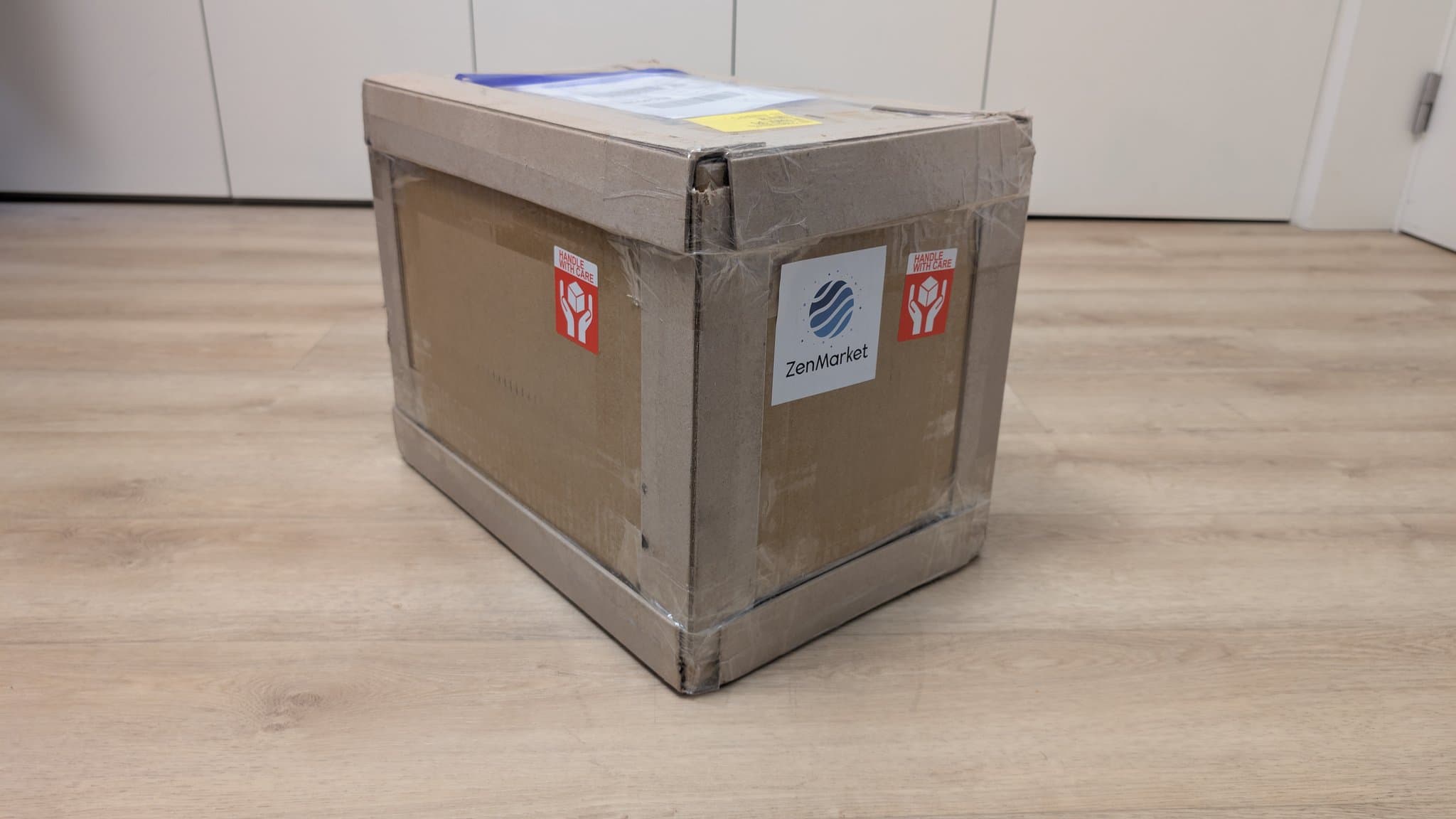 Cardboard shipping box labeled "ZenMarket" with red "Handle with Care" stickers, containing a Sony PVM-6041Q CRT monitor from Japan.