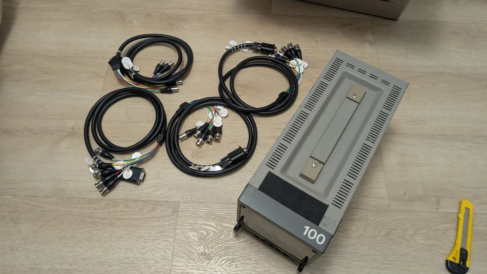 Sony PVM-6041Q 6" CRT monitor with four VGA to BNC cables laid out on wooden floor, yellow measurement tool visible.
