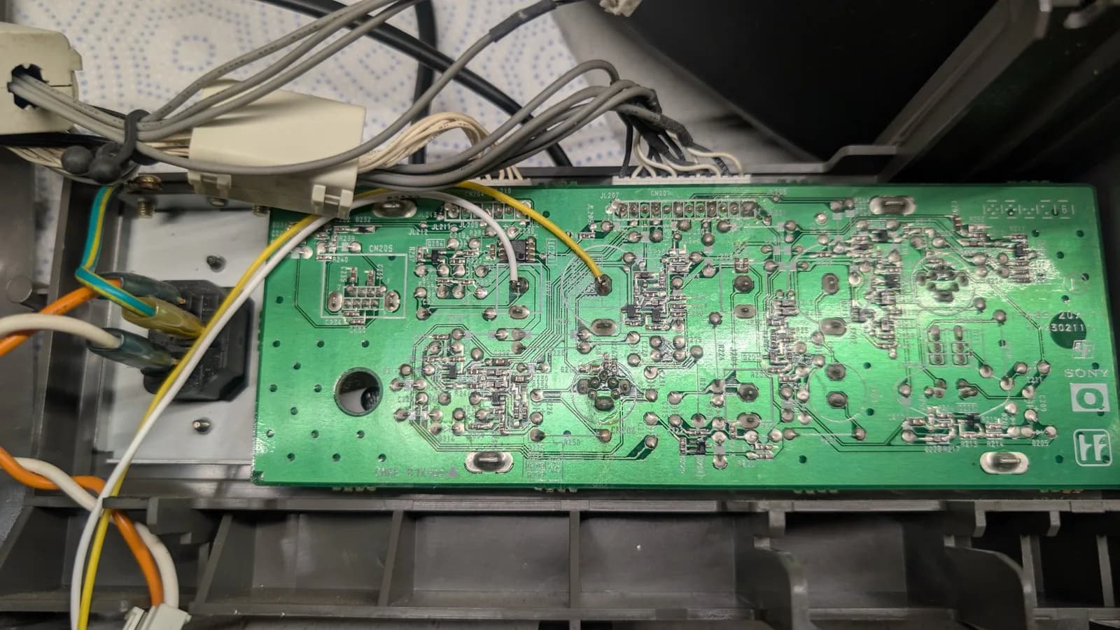 Sony PVM-14L1 RGB mod PCB with soldered wires and connectors, heat-shrink wrapped joints visible during sound and sync wiring installation.