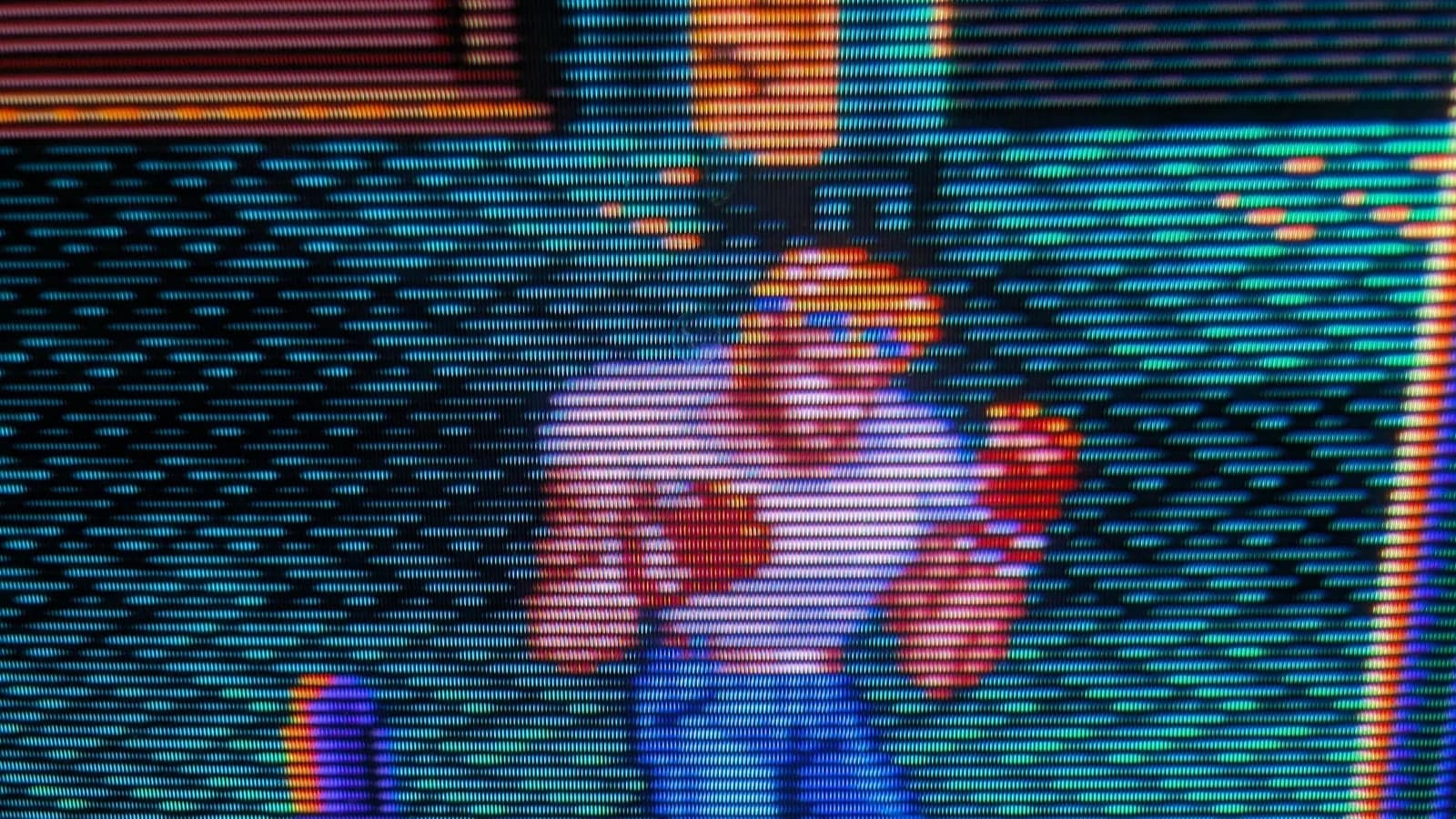 Sony PVM-14L1 displaying vibrant RGB test pattern with cyan, magenta, red, yellow, and blue vertical stripes on CRT screen.
