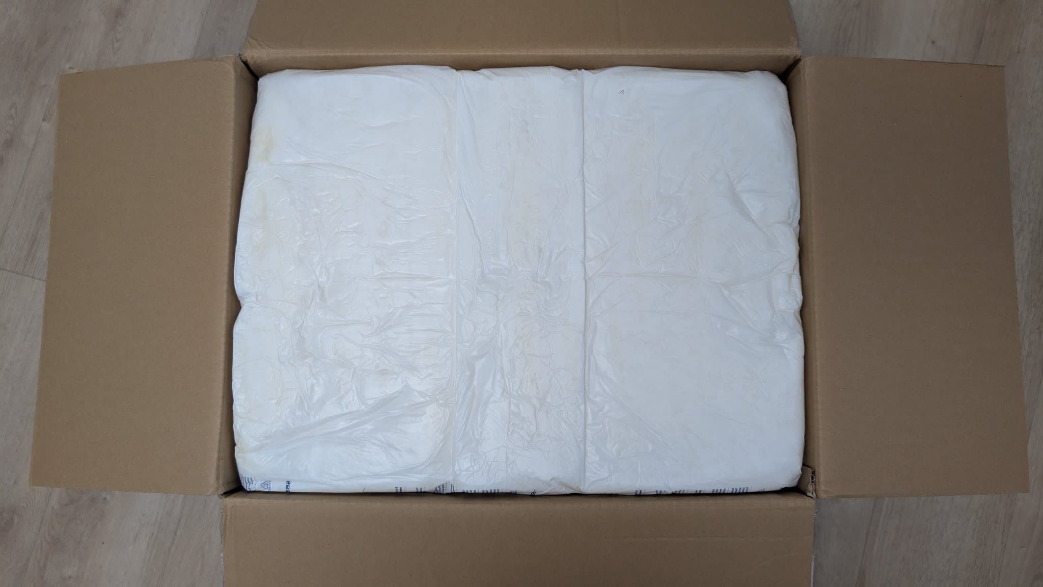 Unboxed Sharp X68000 tower model wrapped in white protective plastic inside cardboard shipping box.