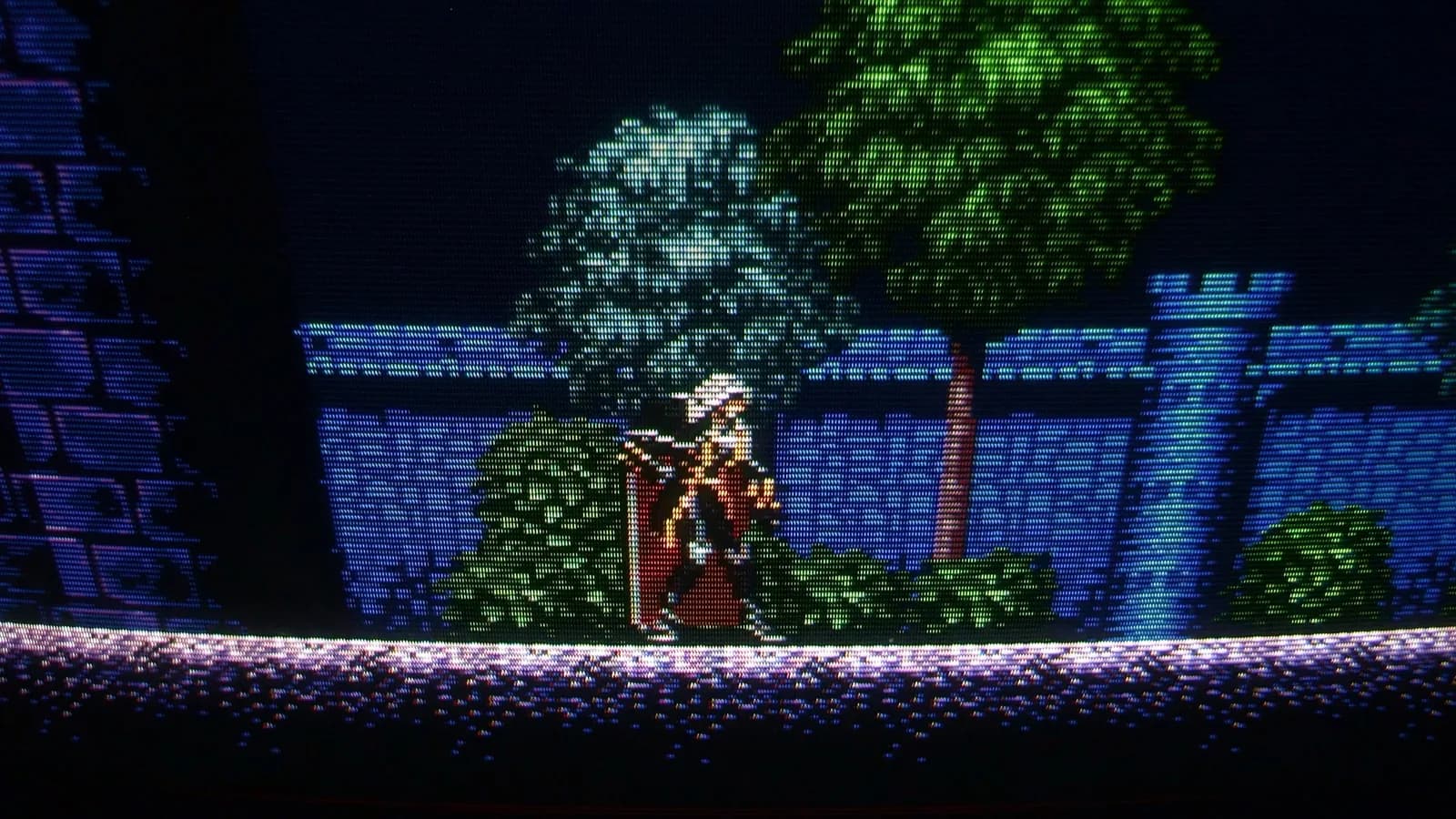 Sony PVM-9045QD showing the Mega Drive homebrew demake of Castlevania: Symphony of the Night, a closer view of Alucard (red cape) before the blue castle wall, with trees and a turret in the castle wall behind.