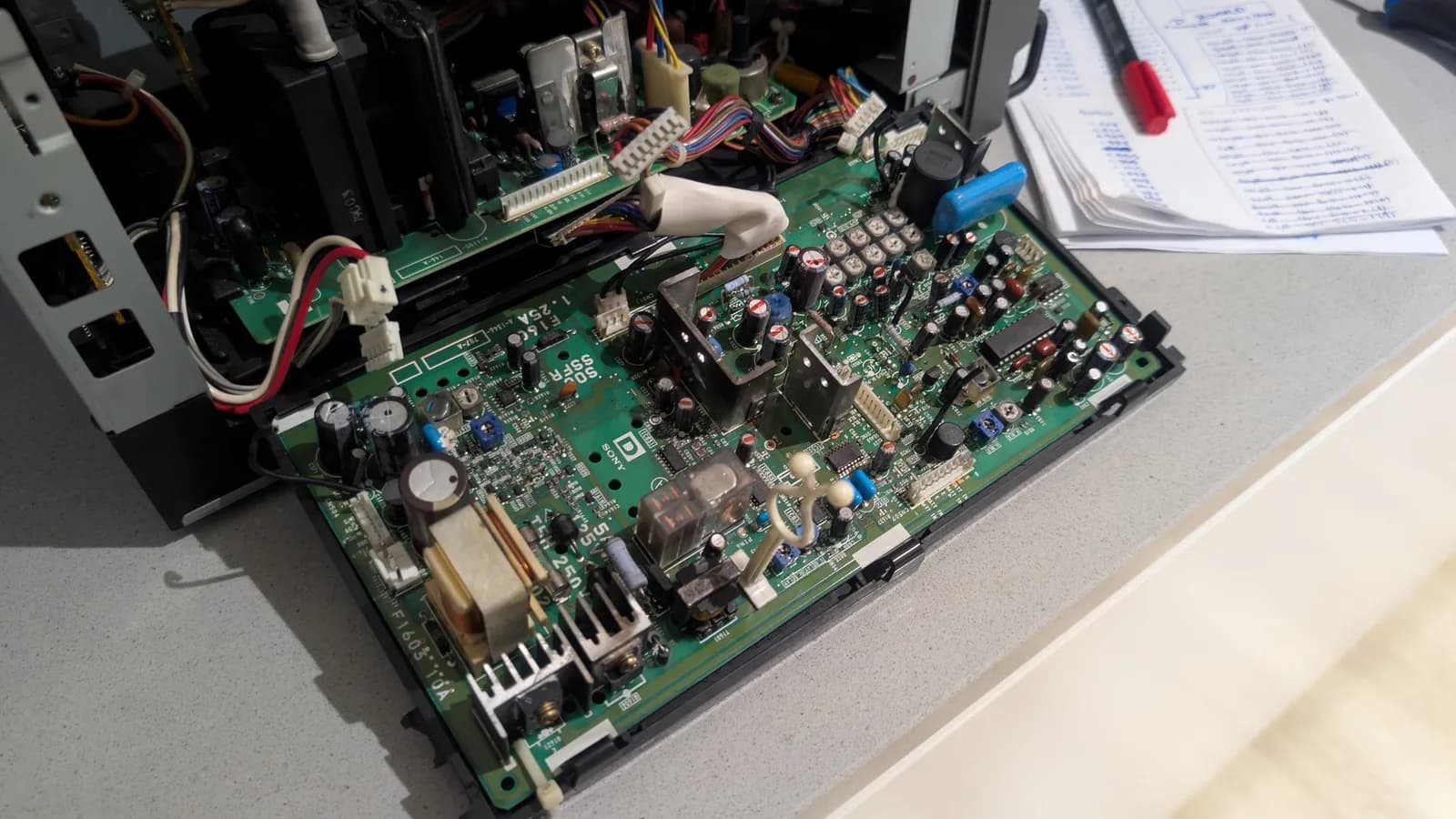 Sony PVM-9045QD deflection board still in its chassis, capacitors marked (the ones to remove with a long dash), mid-recap.
