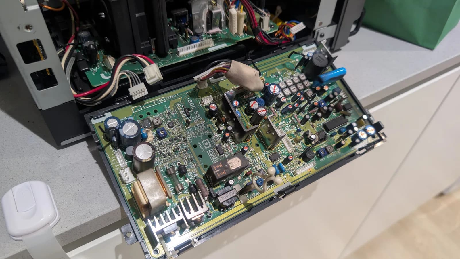 Sony PVM-9041Q deflection board laid out on the bench, the capacitors to replace marked (the ones to remove with a long dash), the opened chassis alongside.
