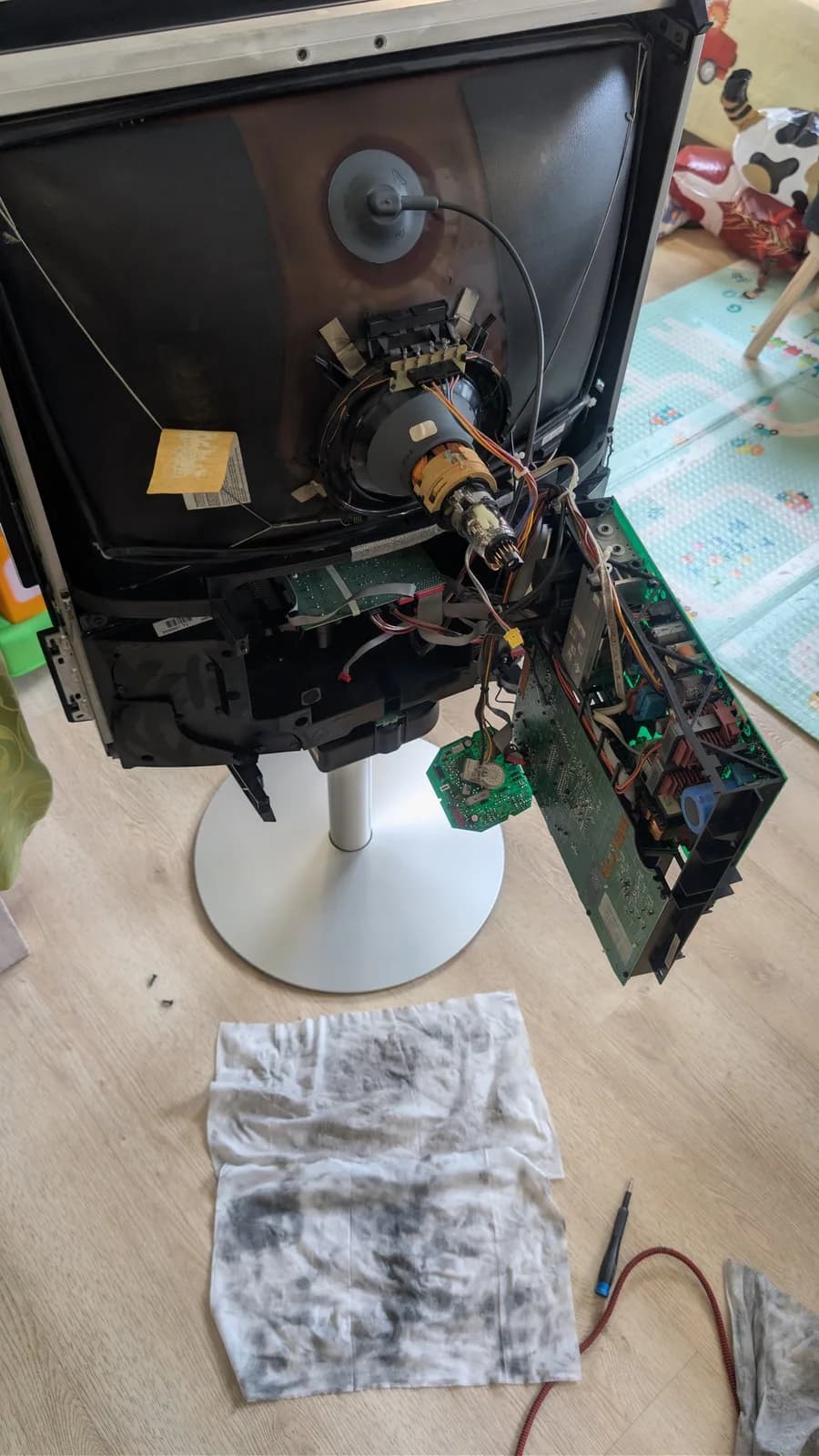 Disassembled B&O Beovision 1 CRT monitor showing internal components, motor, circuit boards, and burnt X2 safety capacitor that caused smoke emission during operation.