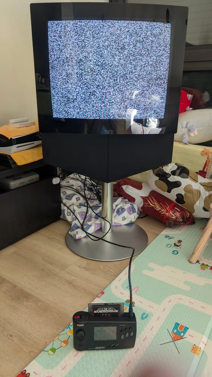 Bang & Olufsen Beovision 1 displaying blue static on screen, connected to Sega Genesis console, showing post-repair power-on test.