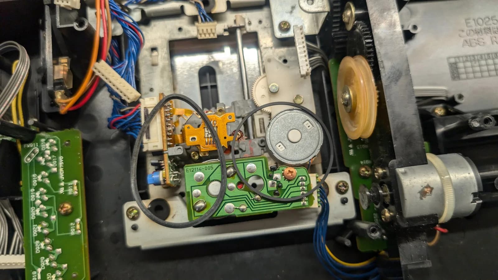 Wondermega drive belt replacement: green circuit board with new belt installed, motor components, and internal chassis visible during repair work.