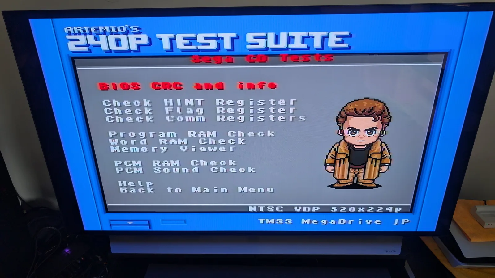Wondermega 240P test suite menu showing BIOS CRC and INFO check passed, with pixelated mascot character in brown jacket on right side.
