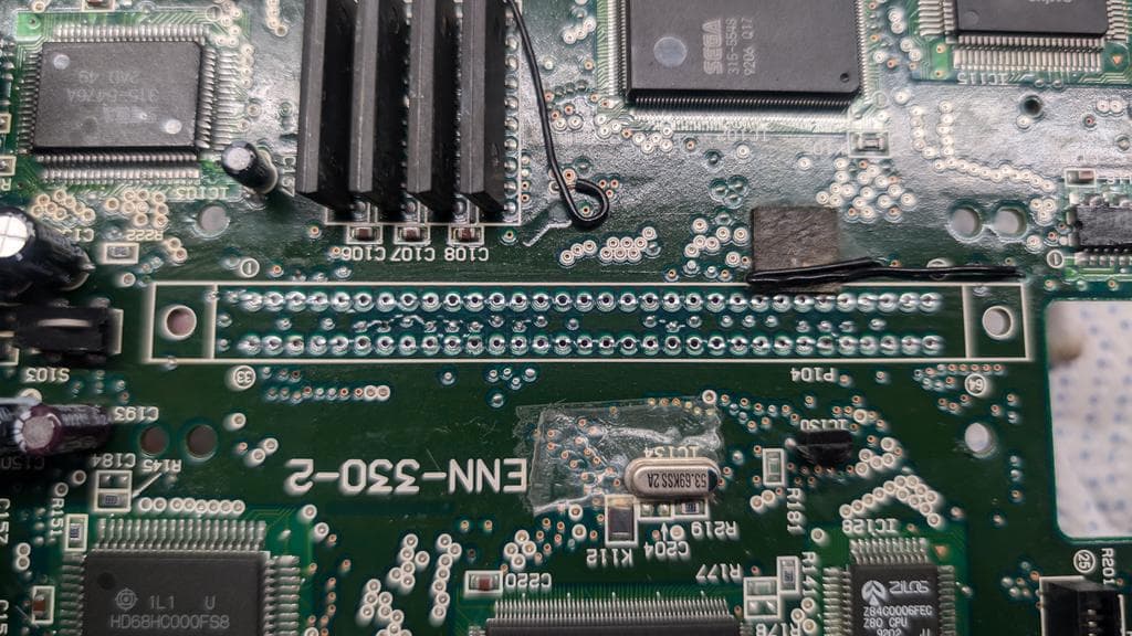 Sega Wondermega PCB topside after cleaning, showing cartridge slot contact holes and reassembled button area with restored functionality.