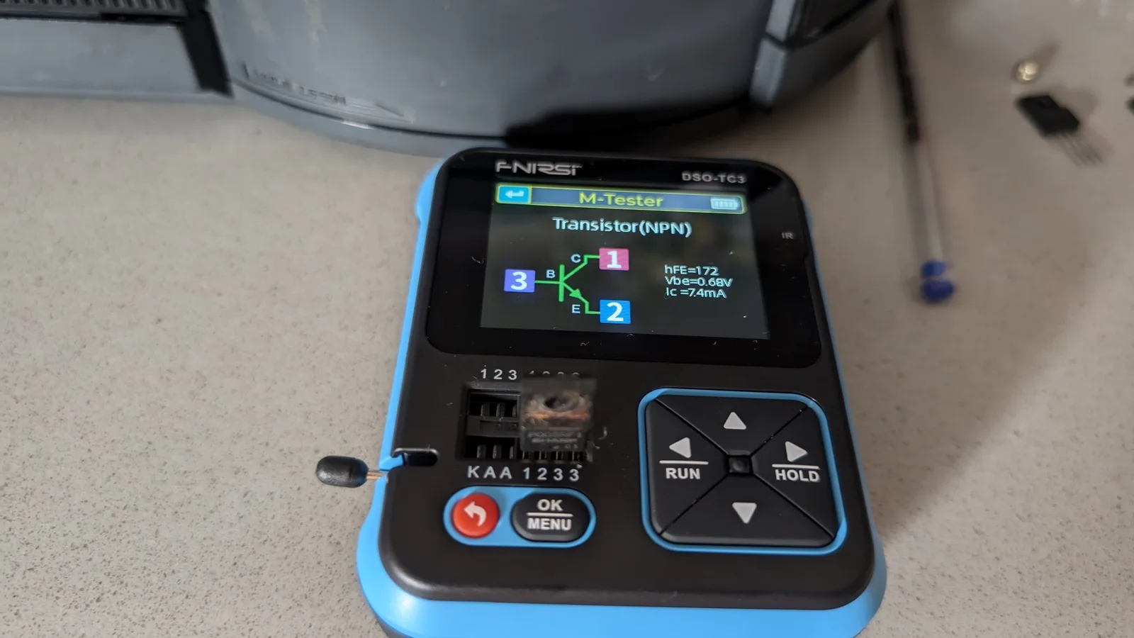 ESR meter testing NPN transistor from Wondermega regulator circuit; hFE=172, Vbe=0.68V, Ic=74mA readings displayed.