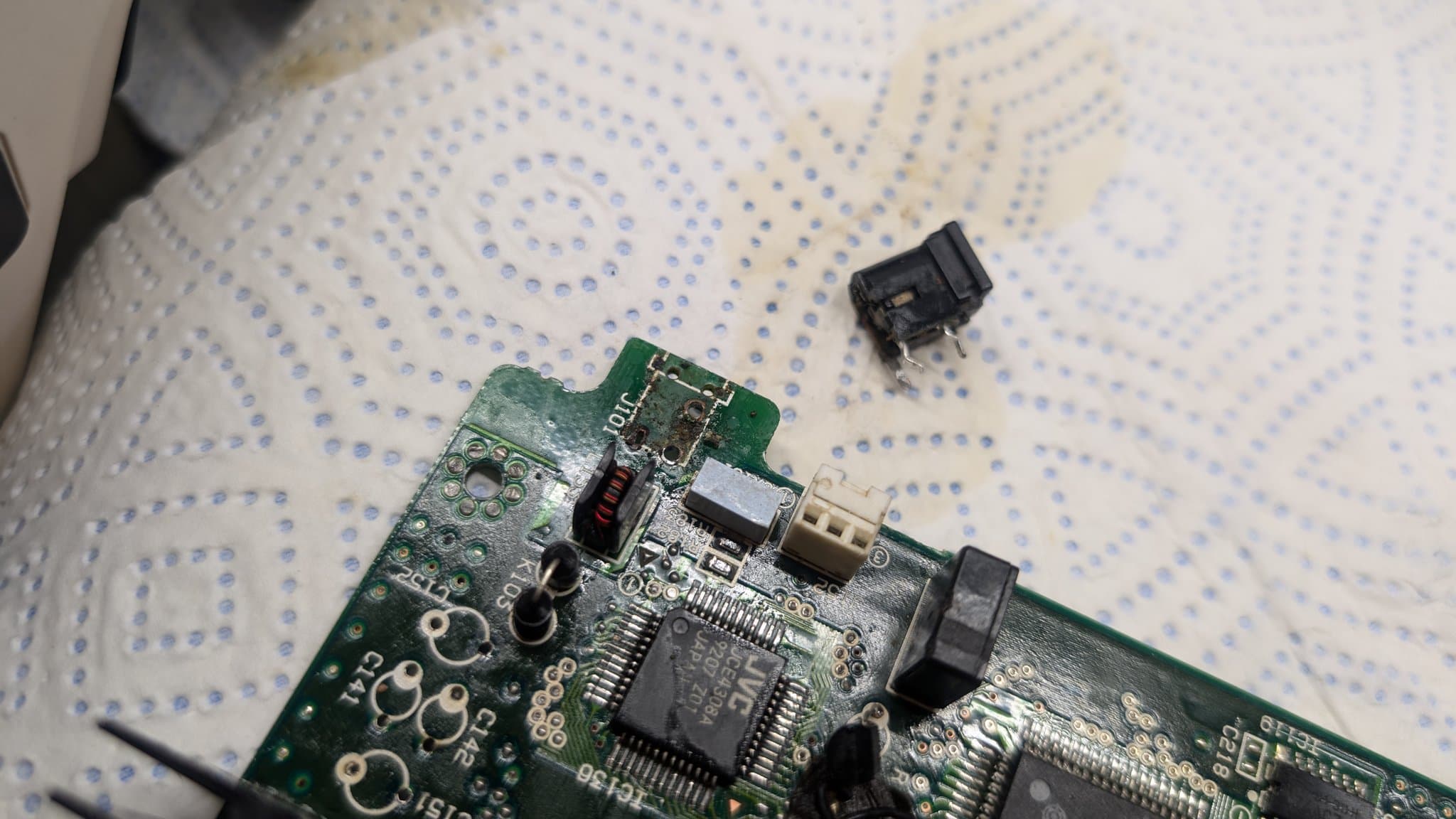 Removed power jack and disconnected switch component beside PCB during corrosion cleaning work on Wondermega board.